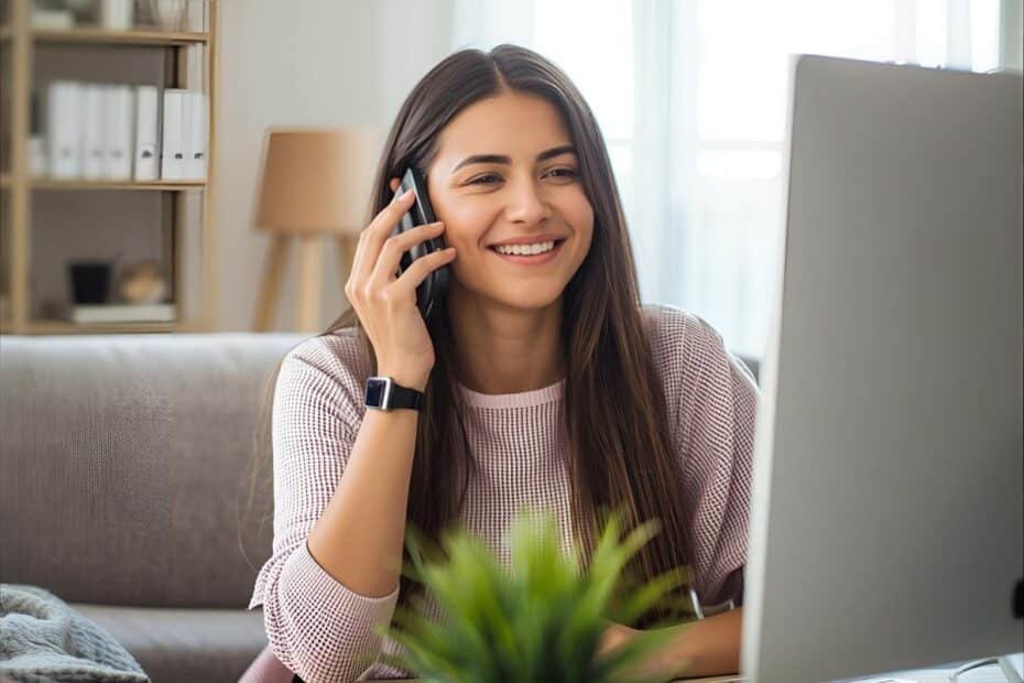 Pessoa trabalhando em casa com celular e computador, ilustrando a Ataa renda extra com trabalhos home office